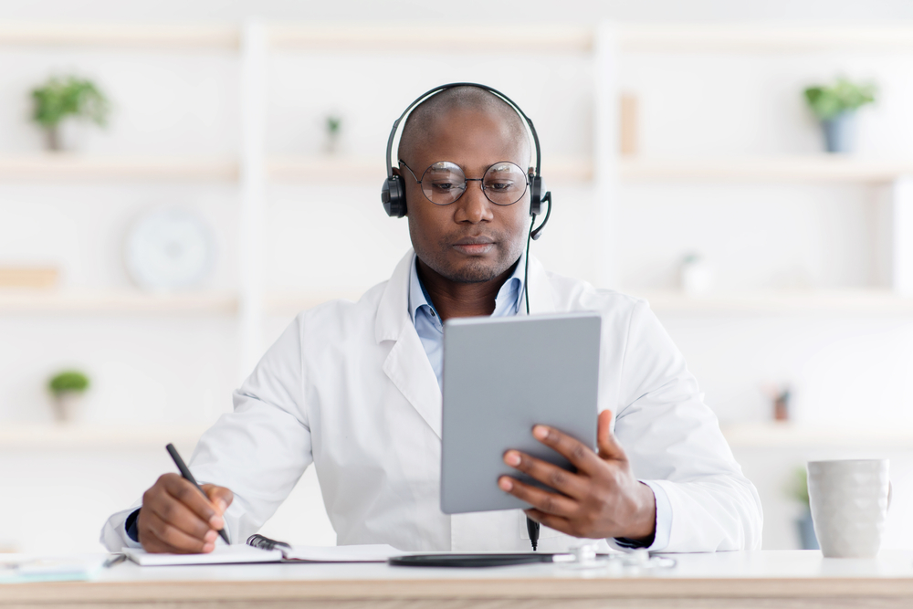 Doctor on computer with headphones
